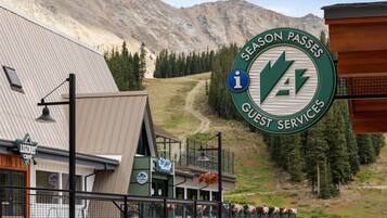 Un edificio con un cartel que indica 'Season Passes Guest Services' y un cartel que anuncia 'Legends Cafe'.