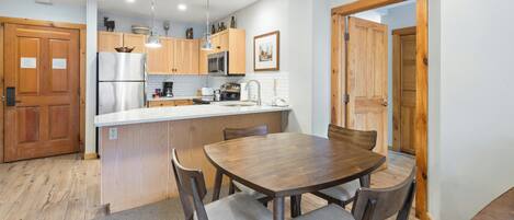 A modern kitchen with wooden cabinets, stainless steel appliances, and a central island with seating.