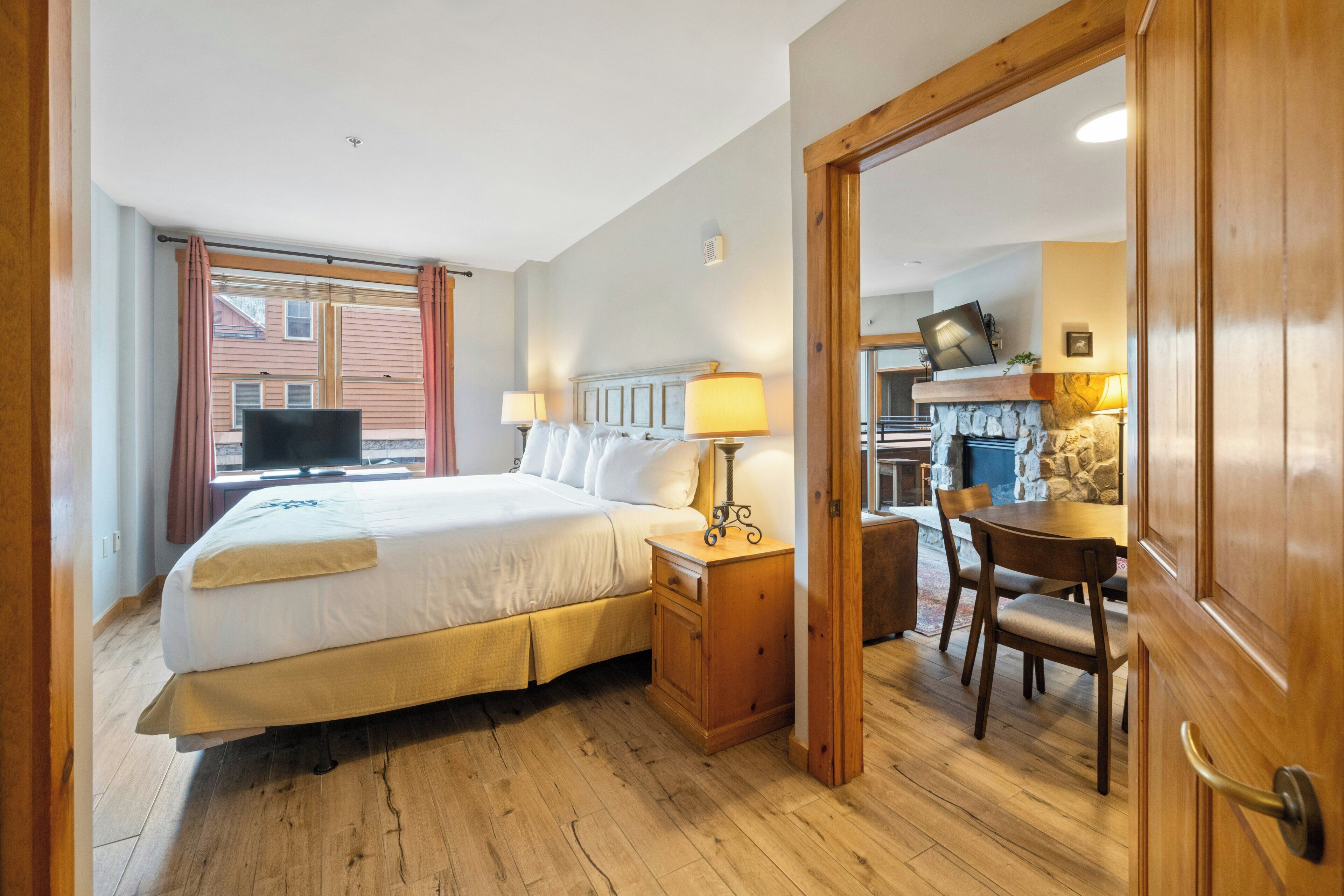 Une chambre d’hôtel avec un lit, une table de chevet, une lampe et une vue sur l’extérieur.
