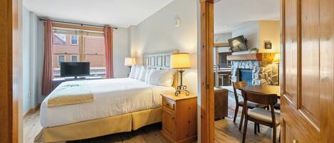Une chambre d’hôtel avec un lit, une table de chevet, une lampe et une vue sur l’extérieur.