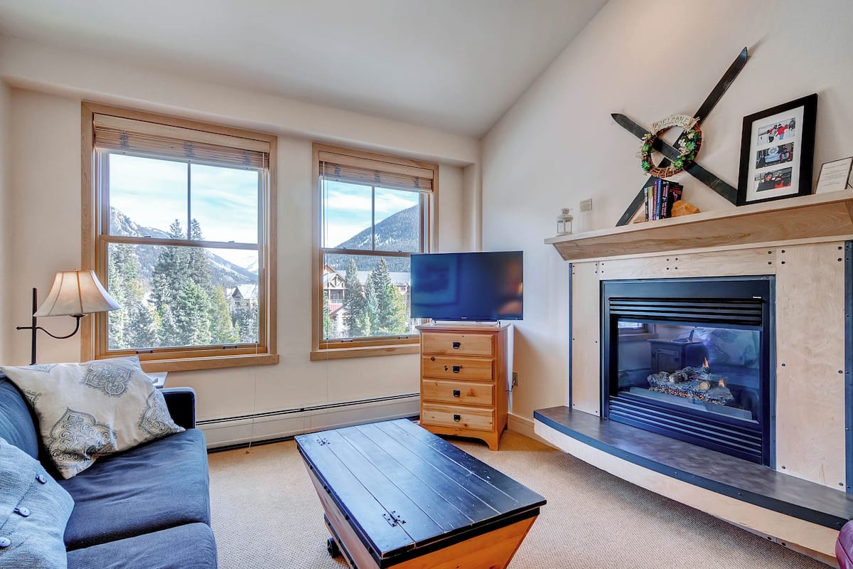 A living room with a fireplace, a television, and a sofa.