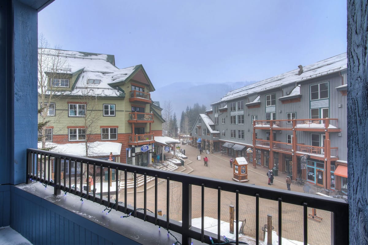 A town square with buildings, a snow-covered street, and a clear sky.