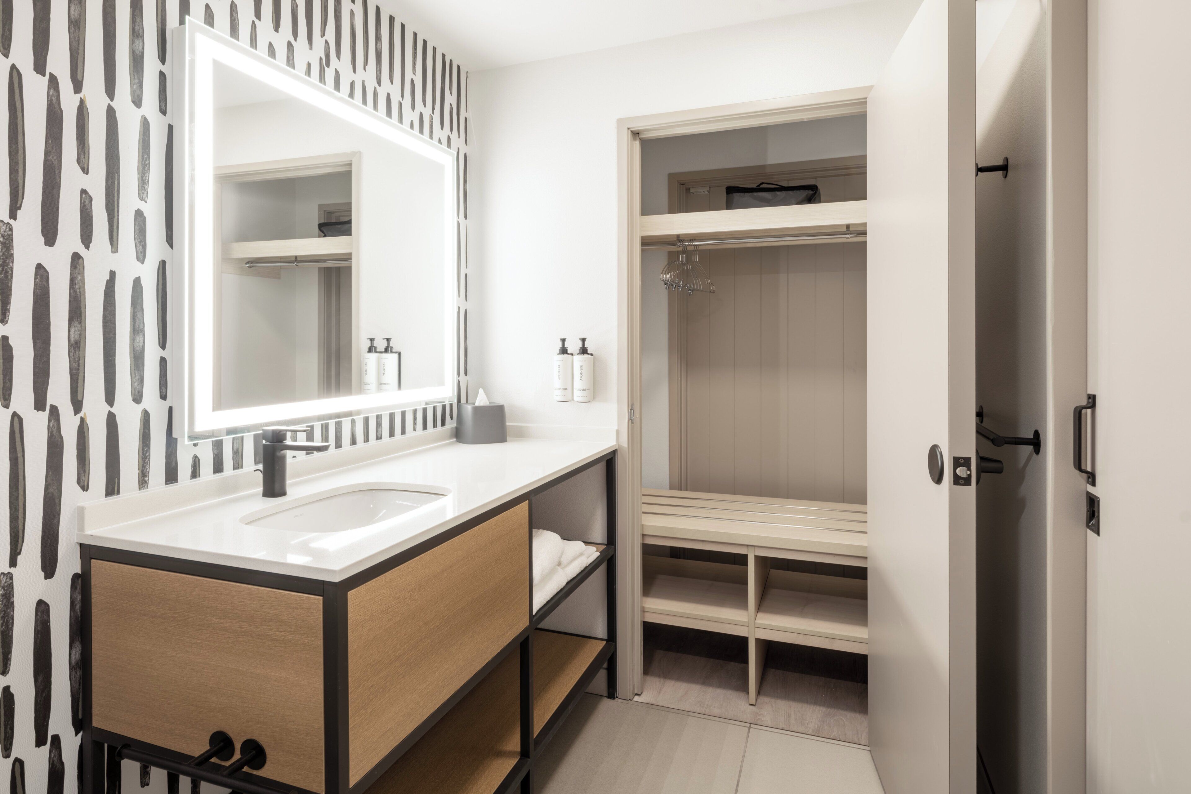 A modern bathroom with a double sink vanity, a mirror, and a walk-in shower.