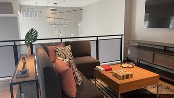 Relax in this stylish living room with a sofa, coffee table, and side table, offering a comfortable space to unwind.