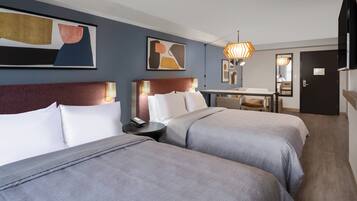 Una habitación de hotel con dos camas, un escritorio y una silla.