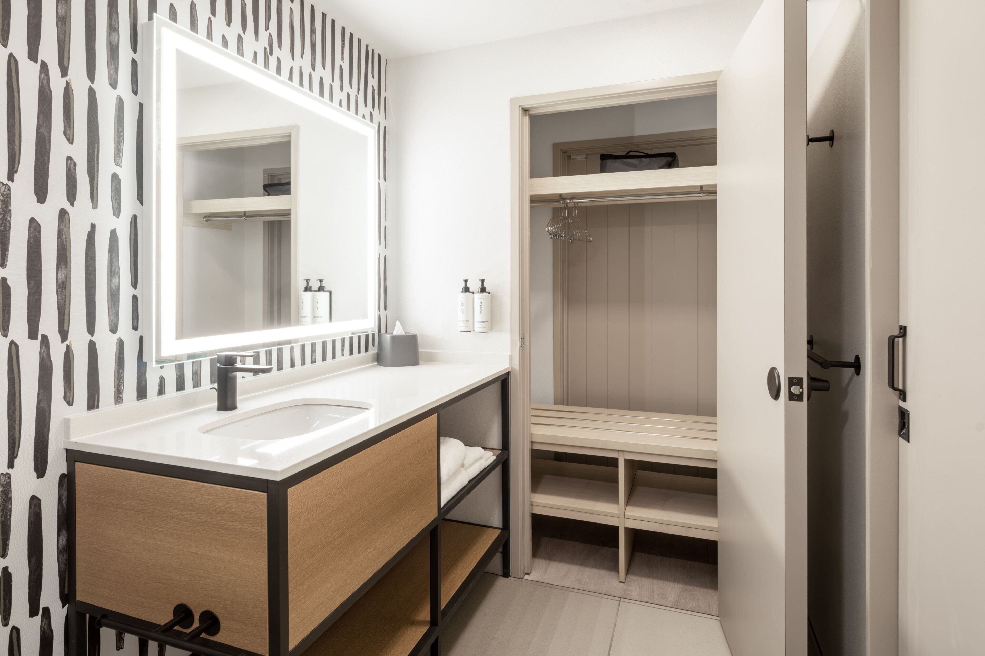 A modern bathroom with a double sink vanity, a large mirror, and a walk-in shower.