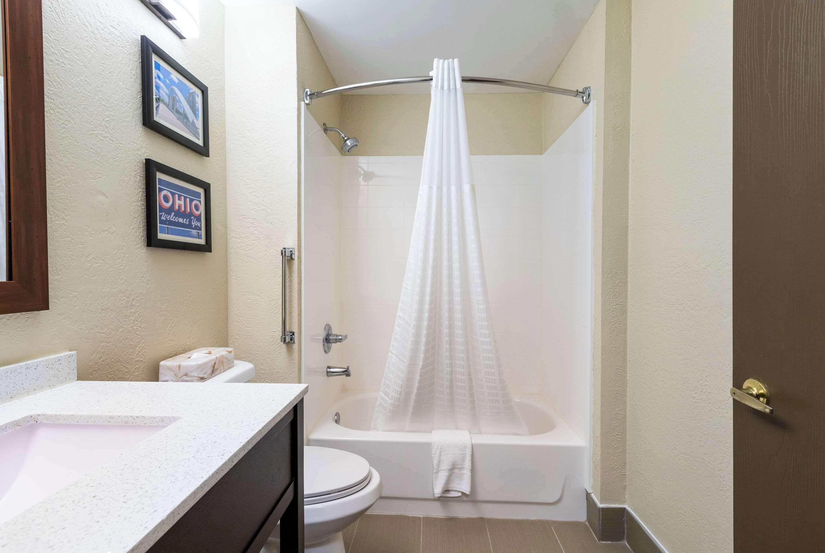 A bathroom with a bathtub, toilet, and sink.