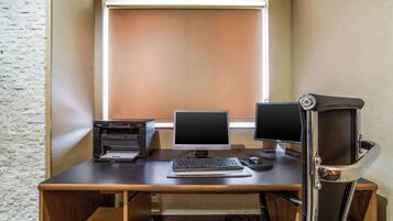 Un espacio de trabajo con escritorio, dos monitores, una impresora y un teclado.