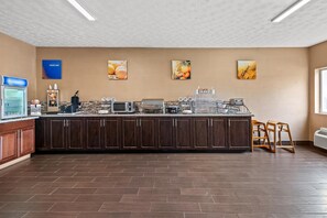 Una cocina amplia con una encimera larga, equipada con varios electrodomésticos y una cafetera.