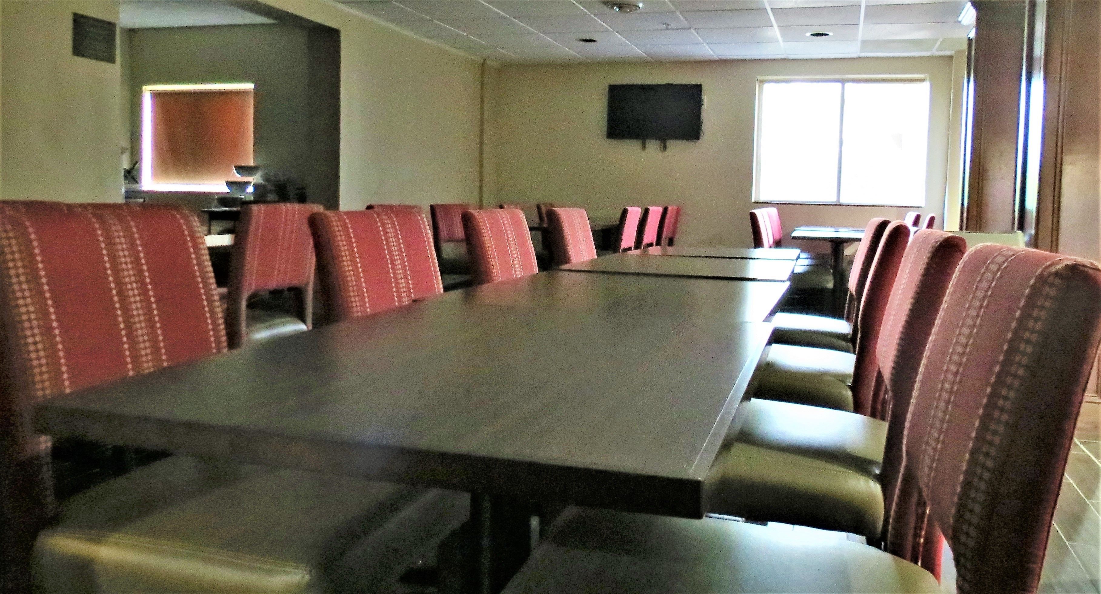 Una sala de conferencias con una larga mesa y filas de sillas.
