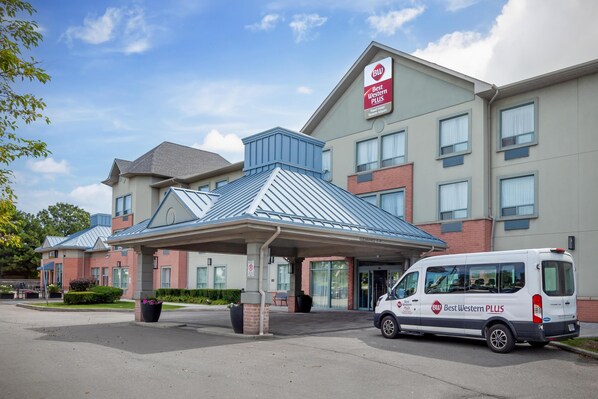 A Best Western PLUS hotel with a covered entrance and a van parked outside.