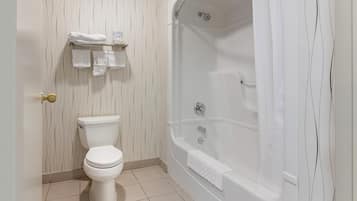 A bathroom with a toilet, a bathtub, and a shower.