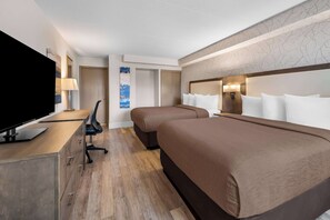 A hotel room with a flat-screen TV, a desk with a chair, two beds with brown bedding, a wardrobe, and a wall-mounted lamp. - Best Western Halton Hills (Halton Hills)