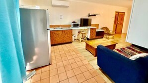 A compact living space with a kitchenette, a dining area, and a sofa. - Townview Motel (Townview)