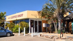 A building with a sign reading "Coffee Shop" and a "Reception" sign. - Townview Motel (Townview)