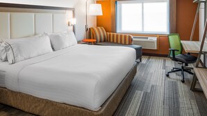 A hotel room with a large bed, a small table, a chair, and a window with a view. - Holiday Inn Express & Suites S Lake Buena Vista by IHG (Kissimmee)