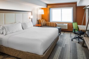 A hotel room with a large bed, a small table, a chair, and a window with a view. - Holiday Inn Express & Suites S Lake Buena Vista by IHG (Kissimmee)