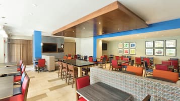 Un restaurante moderno con varias zonas de estar, incluyendo cabinas y mesas.