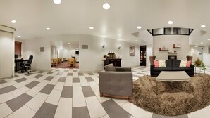 A spacious lobby with a checkered floor, a central seating area with a coffee table, and a reception desk. - Country Inn & Suites by Radisson, DFW Airport South, TX (Irving)