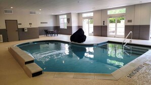 An indoor swimming pool with a no diving sign, a seating area, and a door leading outside. - Country Inn & Suites by Radisson, Houston Intercontinental Airport East, TX (Humble)