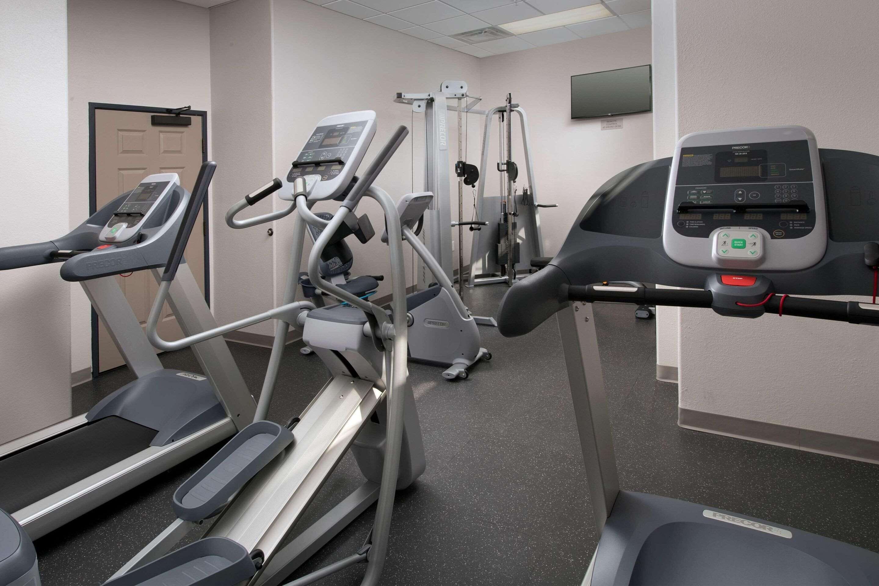 A gym with treadmills, elliptical machines, and weight machines.