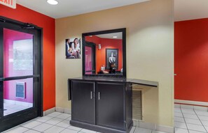 A hotel lobby with a reception desk, a mirror, and a framed picture on the wall. - Extended Stay America Suites Savannah Midtown (Savannah)