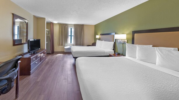 A hotel room with two beds, a TV, a desk, and a chair. - Extended Stay America Suites Stockton March Lane (Stockton)