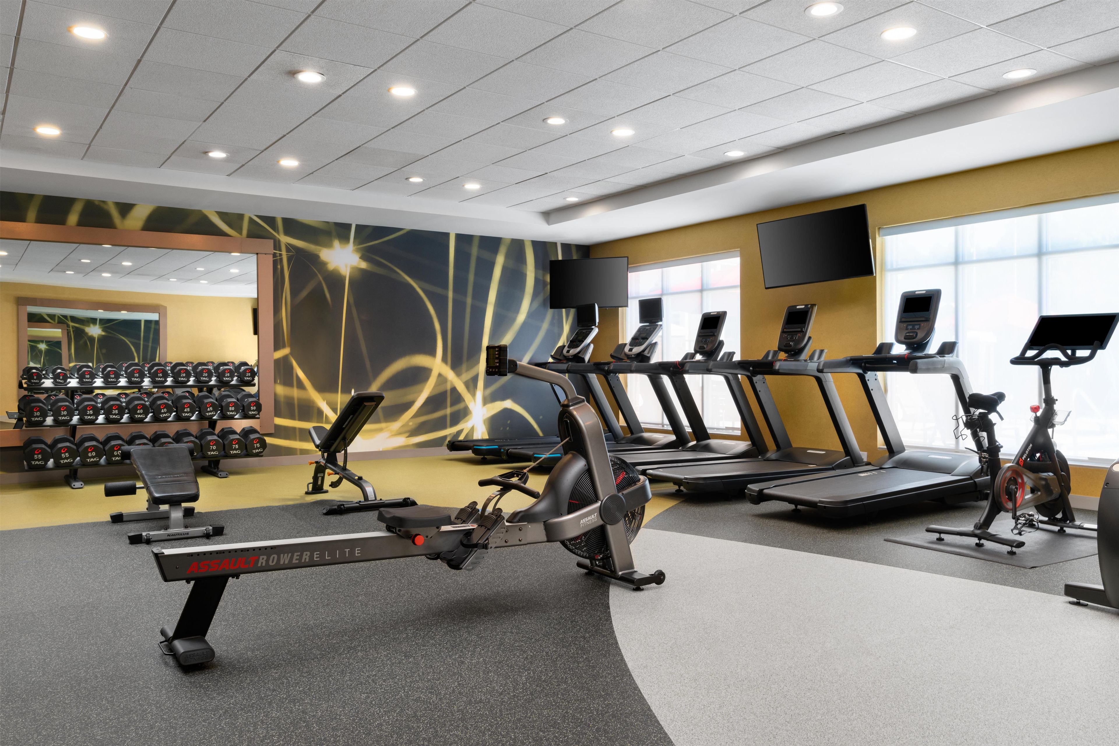 A gym with treadmills, stationary bikes, and weight machines.