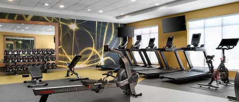 A gym with treadmills, stationary bikes, and weight machines.