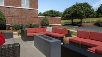 An outdoor seating area with a brick building in the background.
