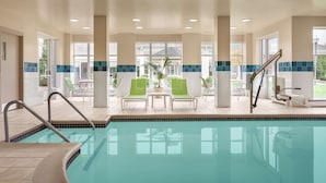 A pool area with a clear view of the pool, green lounge chairs, and a staircase leading to the upper level. - Hilton Garden Inn Bridgewater (Bridgewater)