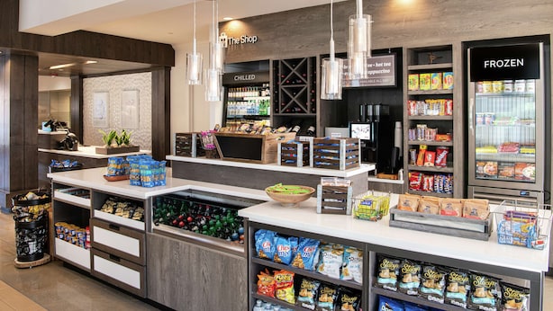 A grocery store interior with a 'The Shop' sign, a 'CHILLED' section, and a 'FROZEN' section.