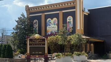 McGoole's Arts & Events Place with outdoor seating and a mural.