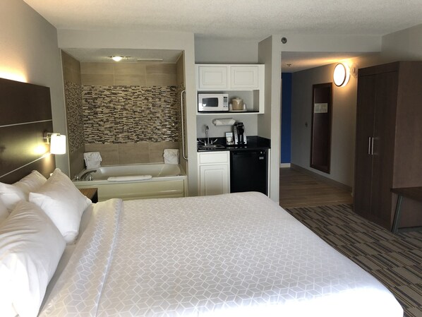 A hotel room with a large bed, a small kitchenette, a bathroom with a shower, and a walk-in closet. - Holiday Inn Express & Suites Quakertown - Allentown Area by IHG (Quakertown)