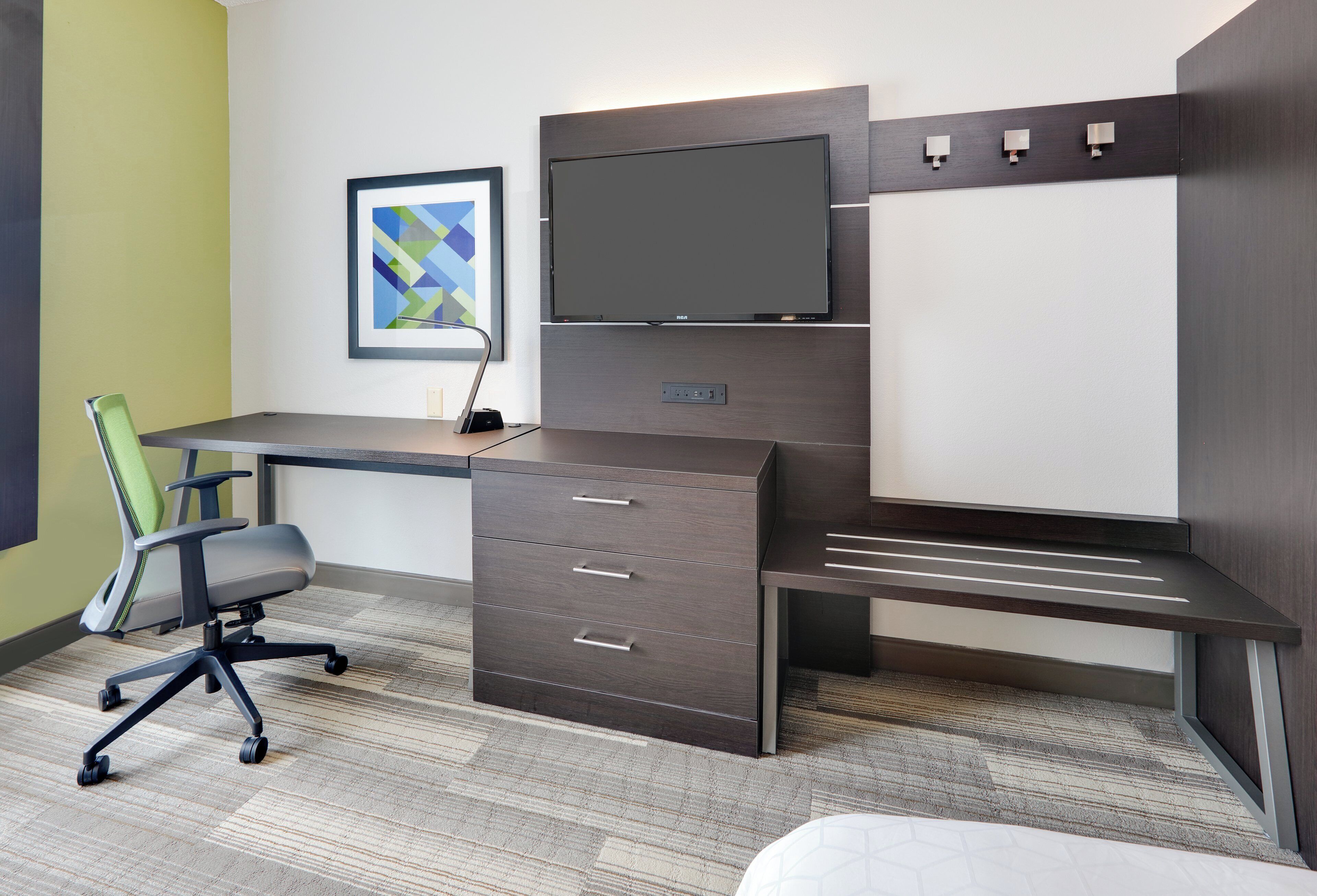 A modern office space with a desk, chair, and a flat-screen monitor.