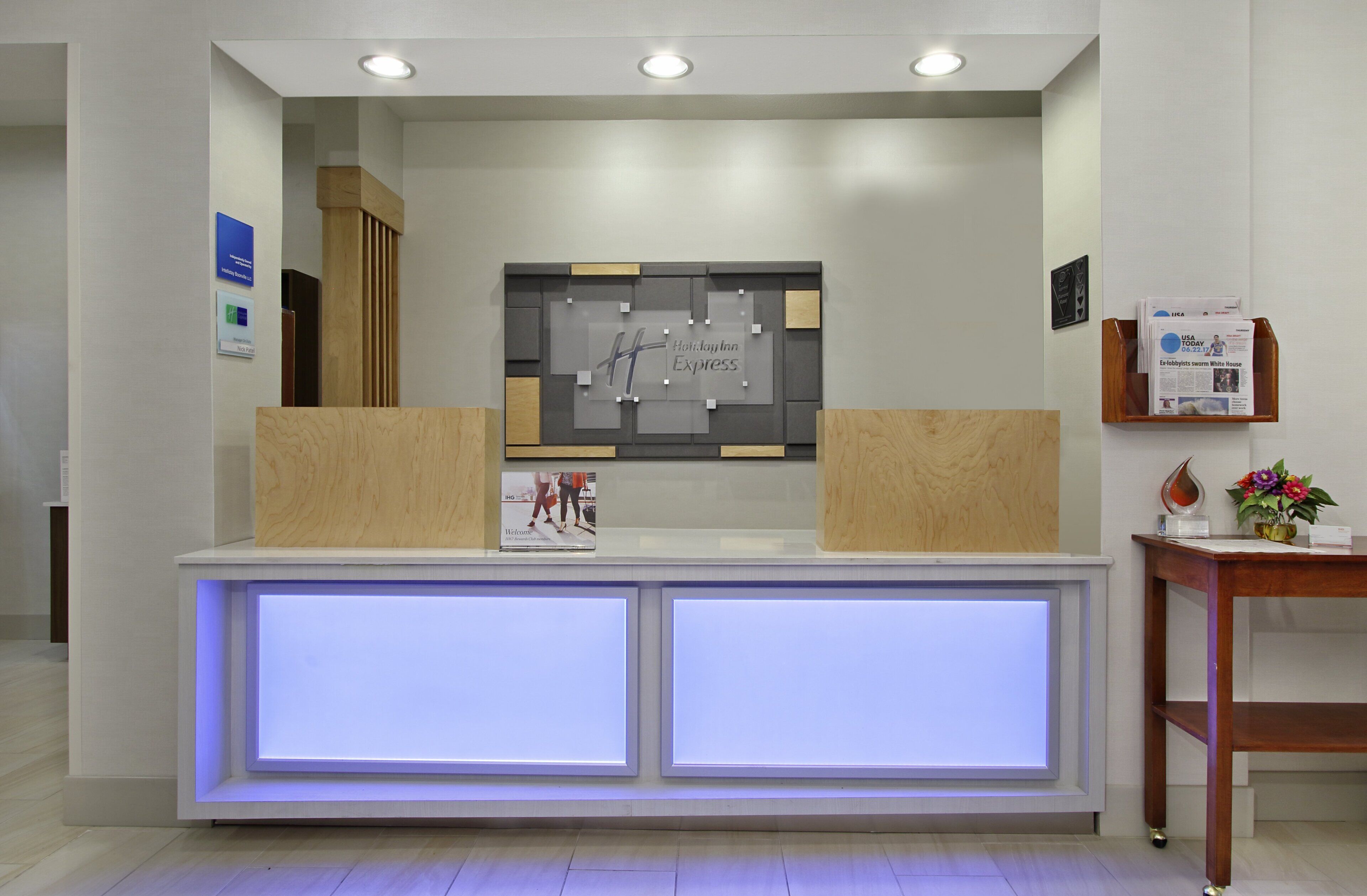 A reception desk with a modern design, featuring a glass partition and a wooden accent.