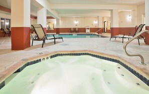 A hotel pool area with multiple lounge chairs and a hot tub. - Holiday Inn Express Boonville by IHG (Boonville)