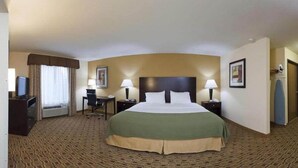 A hotel room with a large bed, two bedside tables with lamps, a desk with a chair, a television, and a wardrobe. - Holiday Inn Express Boonville by IHG (Boonville)