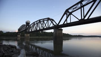 A steel bridge with a tower and a calm river below.
