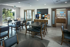 A modern cafe with tables and chairs, a coffee station, and a view of the outdoors. - Holiday Inn Express Corvallis-On the River by IHG (Corvallis)