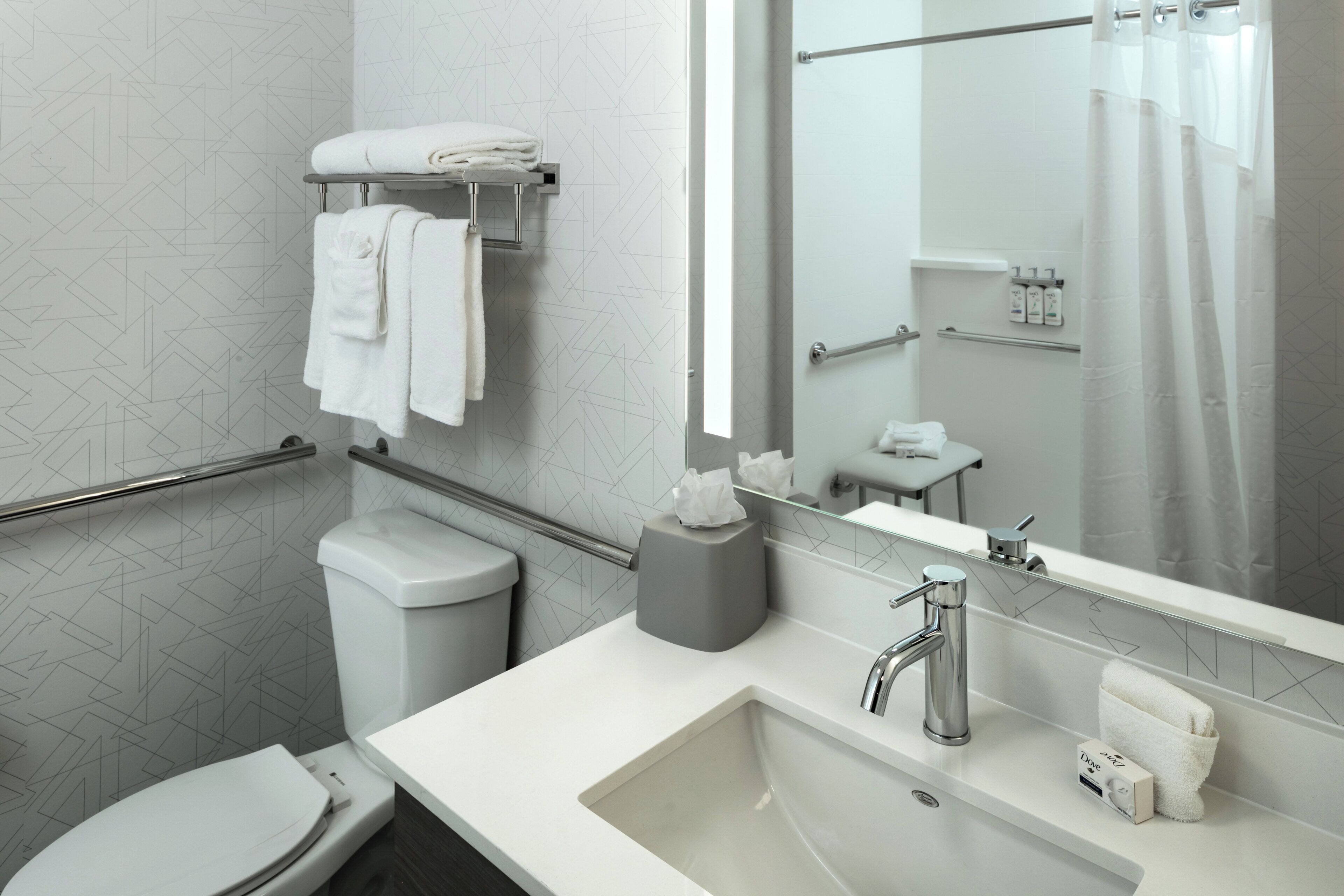 Ein modernes Badezimmer mit Toilette, Waschbecken und Spiegel.