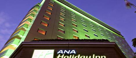 Un edificio alto con un cartel de ANA Holiday Inn Sendaí.