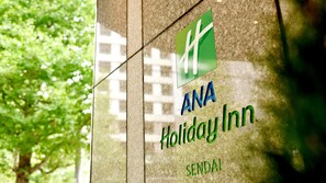 A glass window with the ANA Holiday Inn logo and the location 'Sendai' on it.