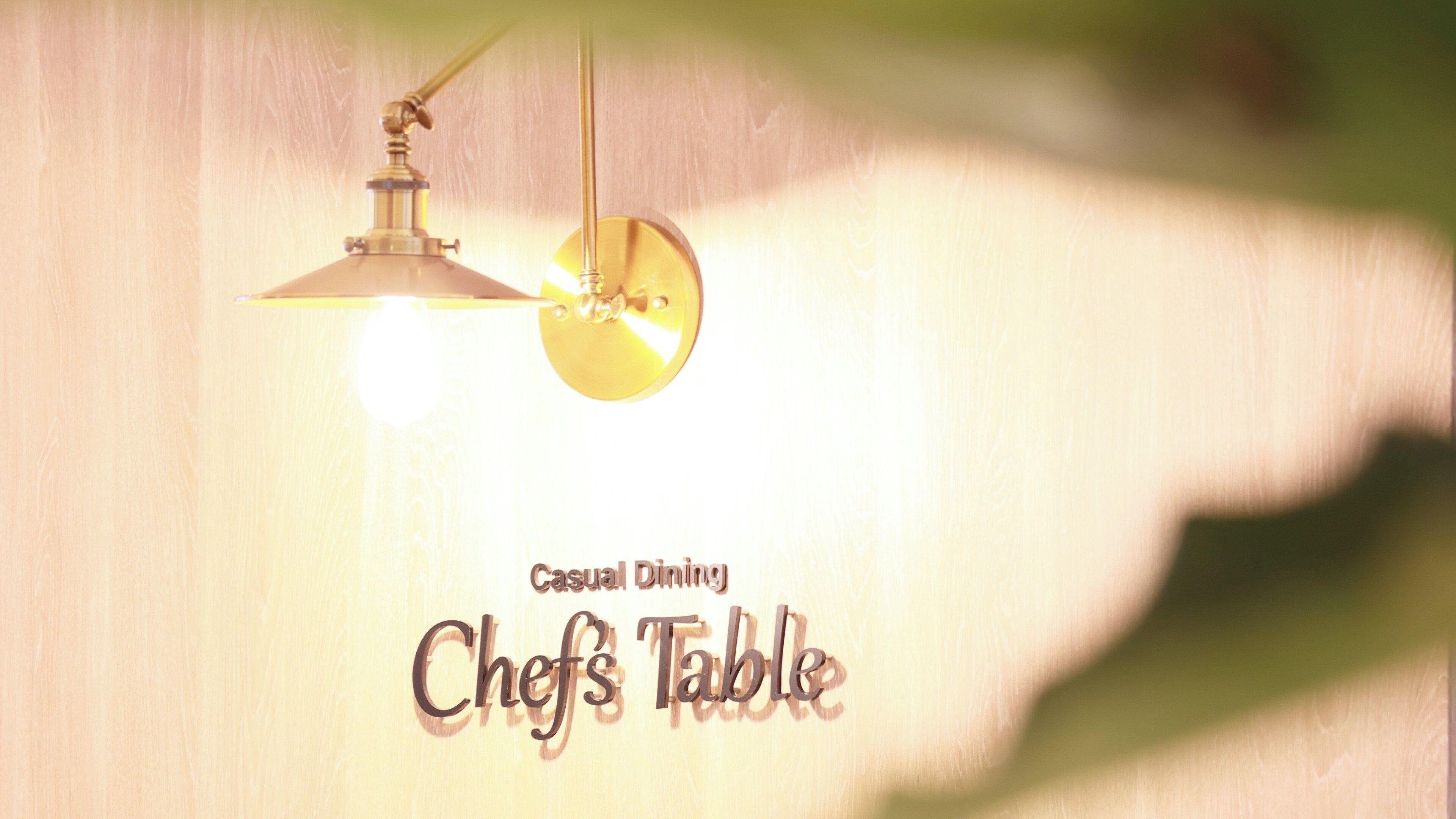A wall with a hanging light fixture and the text 'Casual Dining Chef's Table'.