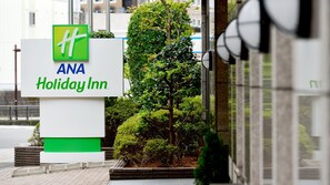A sign for ANA Holiday Inn with a green logo, white background, and blue text. - Holiday Inn ANA Sendai by IHG (Sendai)