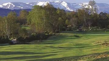 Un campo de golf con montañas al fondo.