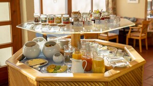 A buffet setup with various food and drink options, including fruits, juices, and condiments. - Filderhotel (Ostfildern)