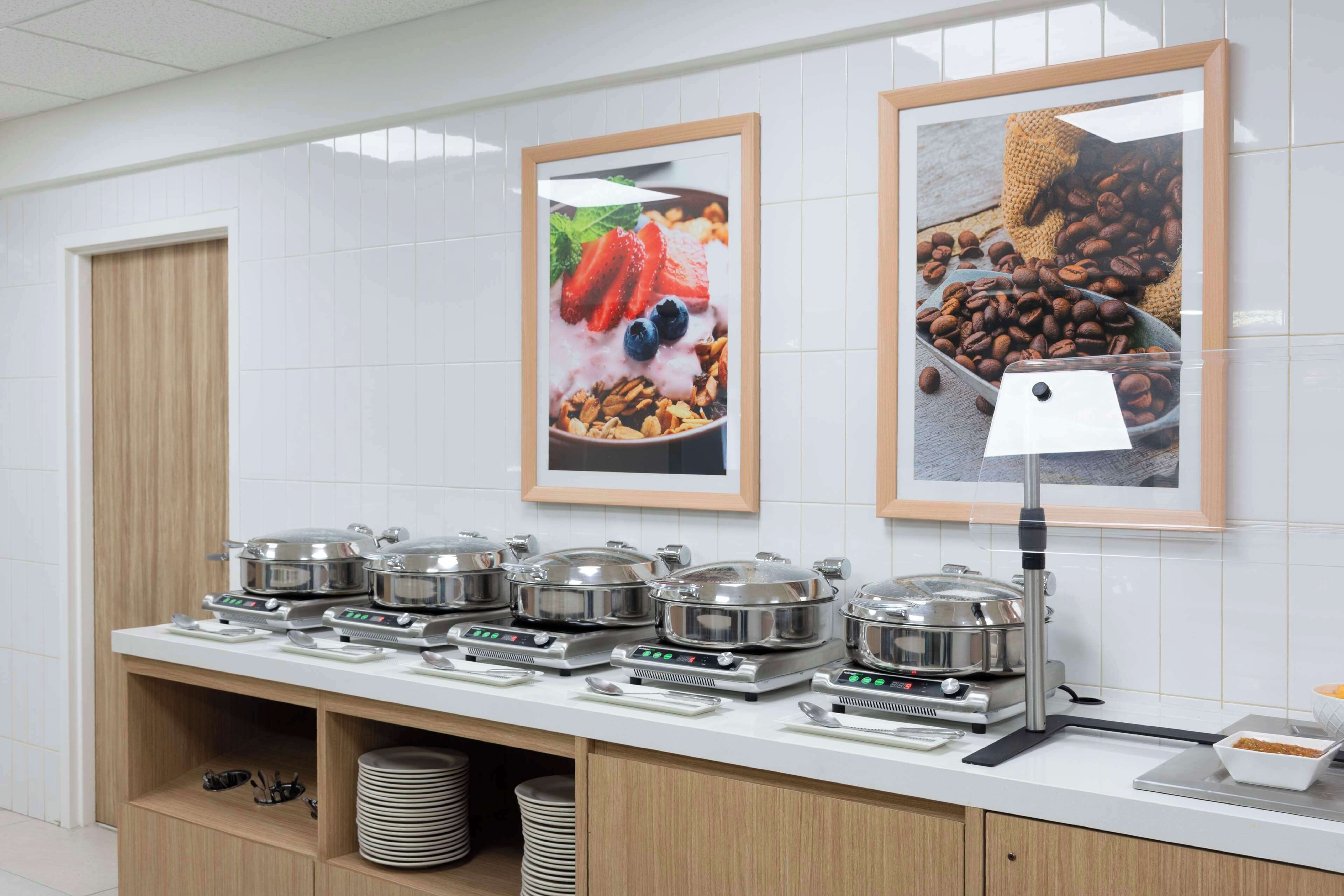 A buffet setup with multiple serving stations, each with a covered food container and a digital scale.