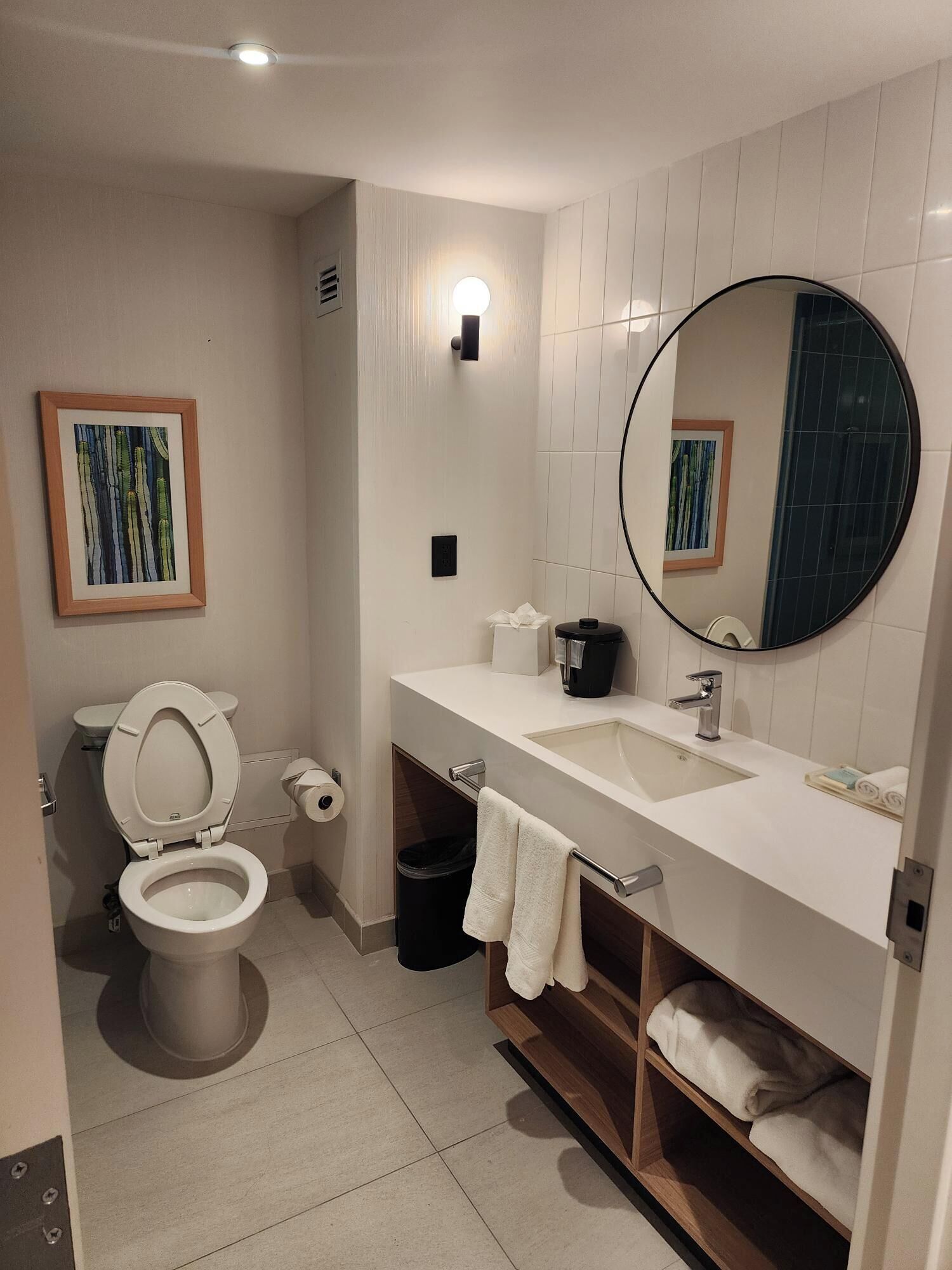A modern bathroom with a toilet, sink, and mirror.