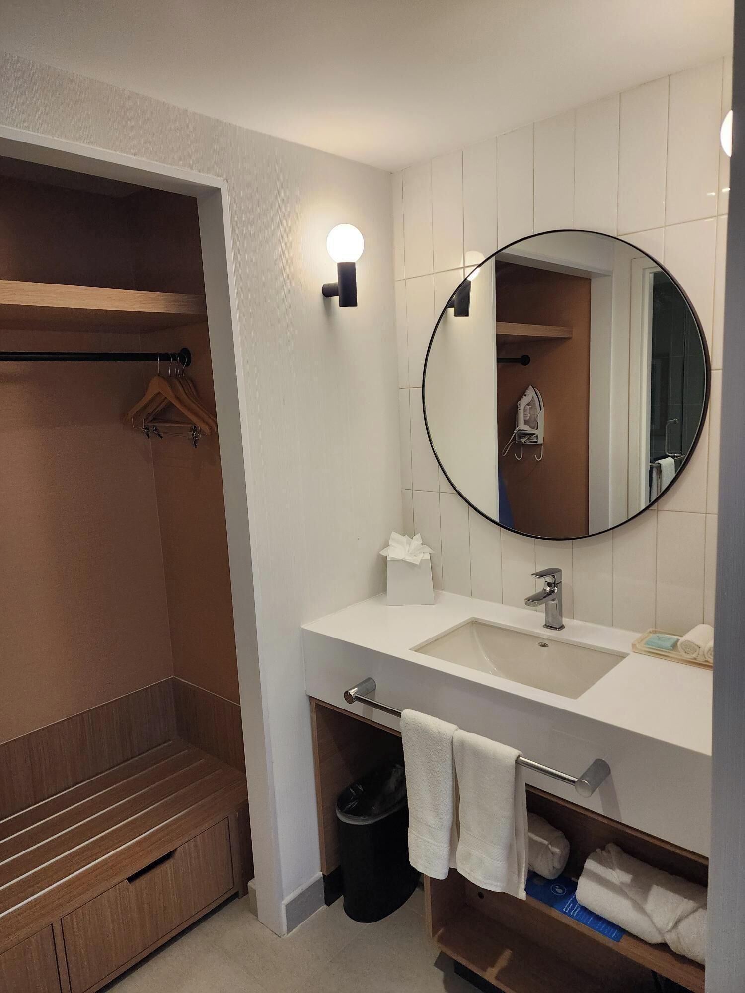 Un bagno moderno con doccia a filo pavimento, un mobile lavabo, uno specchio e un porta asciugamani.